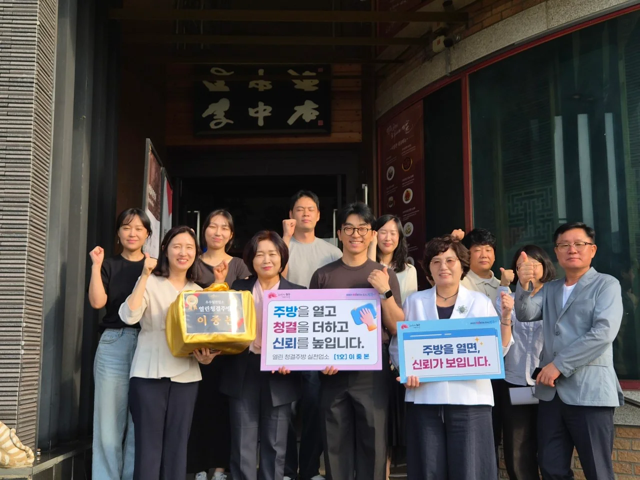 열린 청결주방 실천업소 1호 지정 기념 — 이중본 입구 앞 단체 사진